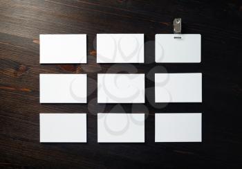 Photo of blank business cards and badge on wooden background. Flat lay.