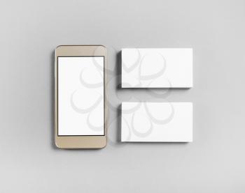 Blank business cards and smartphone on gray paper background. Objects for placing your design. Top view.