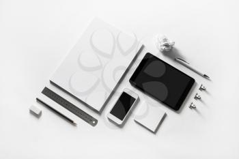 Blank stationery and gadgets at white paper background.