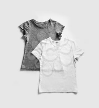 Blank white and gray t-shirts for your design on white paper background. Tshirt template. Flat lay.