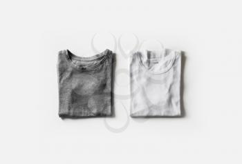 Folded blank gray and white t-shirts on white paper background. Tshirt template for your design. Flat lay.