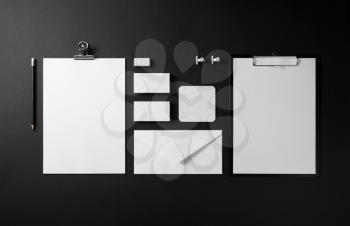 Photo of blank corporate identity. Stationery set on black paper background. Branding mockup. Top view.