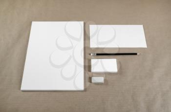 Photo of blank corporate identity. Stationery set. Branding template. Sheets of paper, letterhead, business cards, envelope, pencil and eraser on craft paper background.