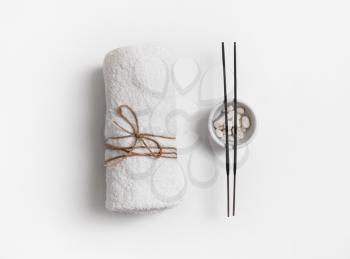 Towel and incense for spa treatments on white paper background. Flat lay.