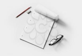 Blank stationery mockup. Blank copybook, glasses, pencil and eraseron white paper background. Template for placing your design.