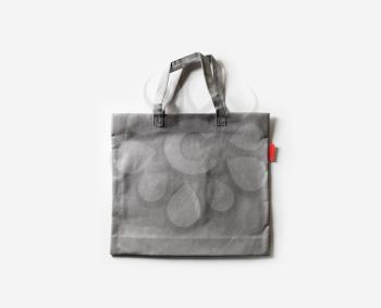 Blank gray fabric canvas bag for shopping on white paper background. Flat lay.