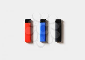 Blank plastic gas lighters on white paper background. Flat lay.