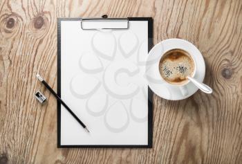 Clipboard with blank letterhead, coffee cup, pencil and sharpener on wooden background. Responsive design template. Top view.