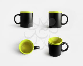 Blank black and light green ceramic mugs. Cups for coffee or tea. Responsive design mockup.