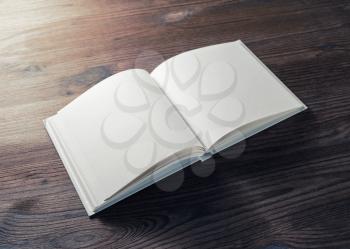 Blank opened book on wooden background. Template for design presentations and portfolios.