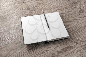 Mockup of opened blank book and pencil on wood table background. Responsive design mockup.