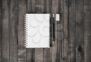 Photo of blank notebook, pencil and eraser on vintage wood table background. Flat lay.