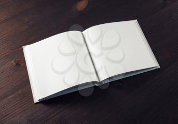 Mockup of open book on wood table background. Responsive design template.