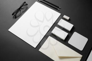 Blank branding stationery mockup on black paper background. Template objects for placing your design. Top view.