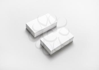Two horizontal blank business cards stacks on paper background.