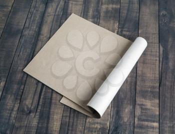 Blank booklet of kraft paper on wooden background.