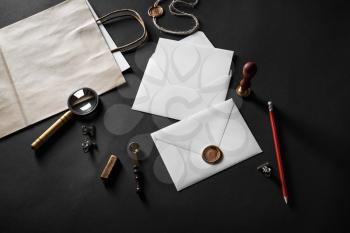 Blank paper envelopes and stationery on black paper background. Responsive design mockup.