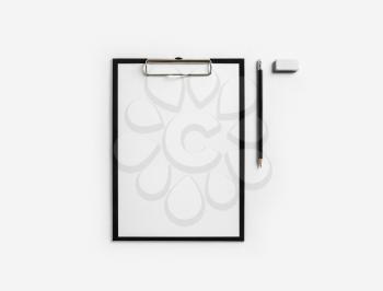 Clipboard with blank letterhead, pencil and eraser on white paper background. Stationery mockup with plenty of copy space. Flat lay.