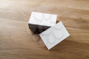 Mockup of blank business cards on wood background.