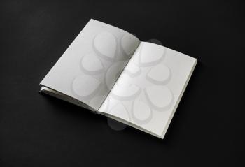 Book, notebook or booklet with blank pages on black paper background.