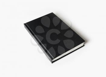 Hardcover canvas book on white paper background. Blank black booklet.