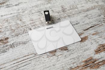 Blank plastic badge. Template for ID. White id card on wooden background. Mock-up for branding identity.