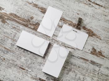 Photo of blank business cards and badge. Photo of blank stationery on wood table background. Flat lay.