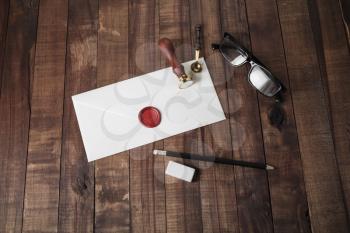 Blank envelope and stationery on wooden background.