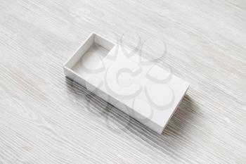 White cardboard box on light wooden background. Responsive design template.