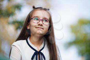 Portrait of child girl with long hair. Schoolgirl with glasses. Selective focus.
