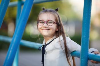 Happy child girl on the playground. Portrait of smiling schoolgirl. Selective focus.