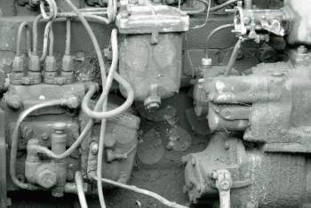 Old dirty engine. Under the hood of a disused car. Monochrome photo.
