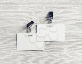 Two blank plastic badges mockup on light wood table background. Empty ID mock up. Copy space for text. Flat lay.