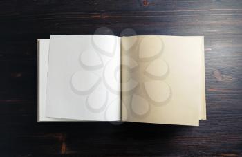 Blank notepad or sketchbook on dark wood table background. Copy space for text. Flat lay.