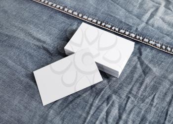 White paper business cards on denim background.