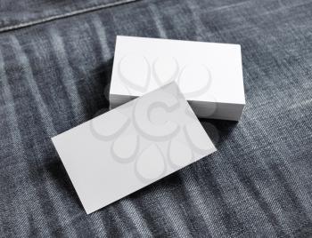 Blank name cards on denim background. White paper business cards