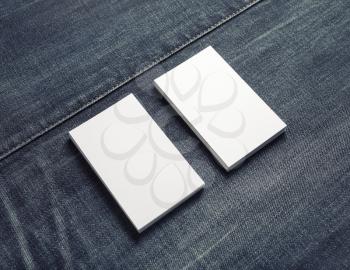 Mockup of two blank vertical business cards on denim background.