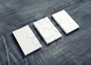 Photo of blank name cards on denim background. Mockup of three business cards.