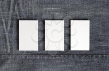 Mockup of three blank vertical business cards on gray denim background. Copy space for text. Flat lay.