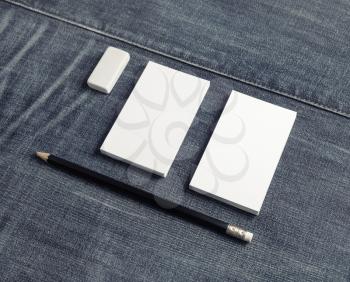 Blank name cards, pencil and eraser on denim background. Copy space for placing your design.