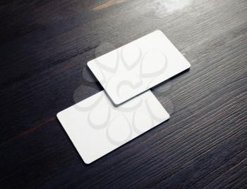 Photo of two blank white business cards on wooden background. Branding ID template.