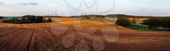 Panoramic rural landscape. Plowed field in the evening.
