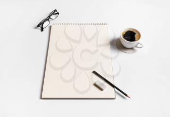 Photo of blank sketchbook, coffee cup, glasses, pencil and eraser on paper background. Blank stationery set. Responsive design template.