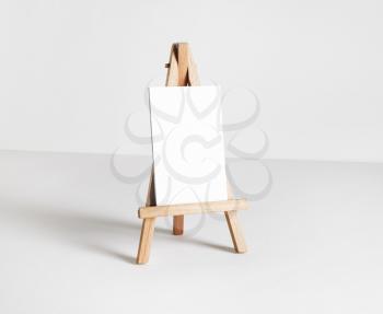 Blank business card on wood holder at white paper background. Responsive design template.