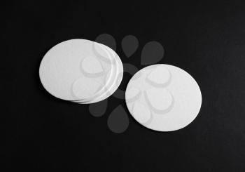 Photo of blank beer coasters on black paper background.