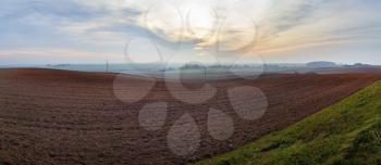Panorama of arable land. Agricultural rural landscape. Evening in the countryside. Panoramic shot.