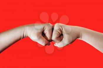 Two female fists hitting each other on red background. Hands clenched into fists. Fight concept.