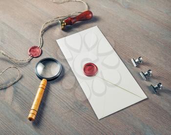 Vintage letter envelope with red wax seal, stamp and magnifier on wood table background. Mock-up for your design.