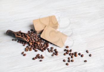 Photo of blank kraft business cards, coffee beans on light wooden background.