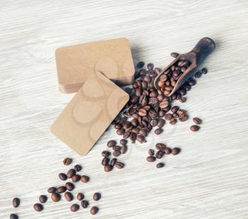 Blank retro business cards and roasted coffee beans on light wood table background. Business brand template.
